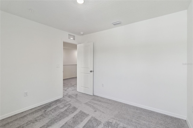 empty room with baseboards, carpet, and visible vents