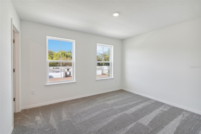 carpeted empty room with baseboards