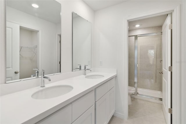 bathroom with a sink, tile patterned floors, a shower stall, and double vanity