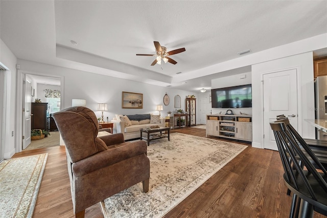 16386 Heron Hills Dr, Spring Hill, FL 34610 - living room featuring visible vents, ceiling fan, wood finished floors, and a raised ceiling