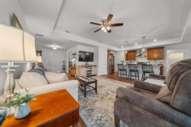 16386 Heron Hills Dr, Spring Hill, FL 34610 - living area with a ceiling fan, wood finished floors, a raised ceiling, visible vents, and recessed lighting