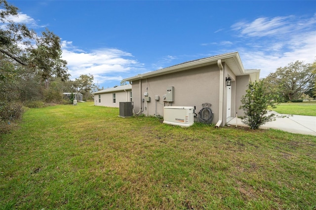 16386 Heron Hills Dr, Spring Hill, FL 34610 - view of side of home with central air condition unit, a lawn, stucco siding, and driveway