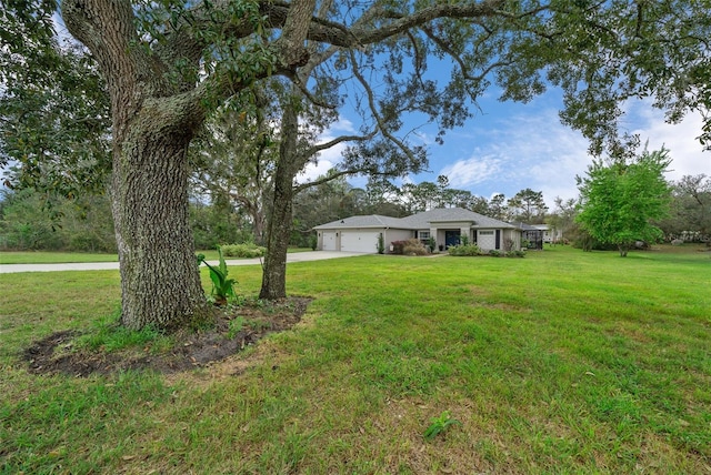 16386 Heron Hills Dr, Spring Hill, FL 34610 - view of yard with driveway and a garage