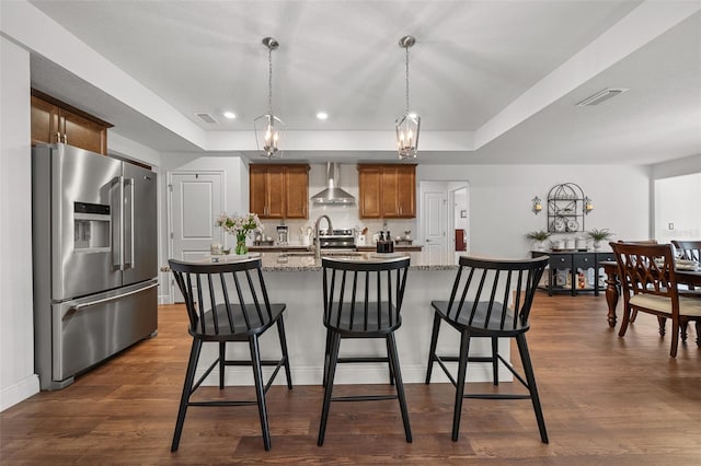 16386 Heron Hills Dr, Spring Hill, FL 34610 - kitchen with wall chimney exhaust hood, visible vents, a raised ceiling, and appliances with stainless steel finishes