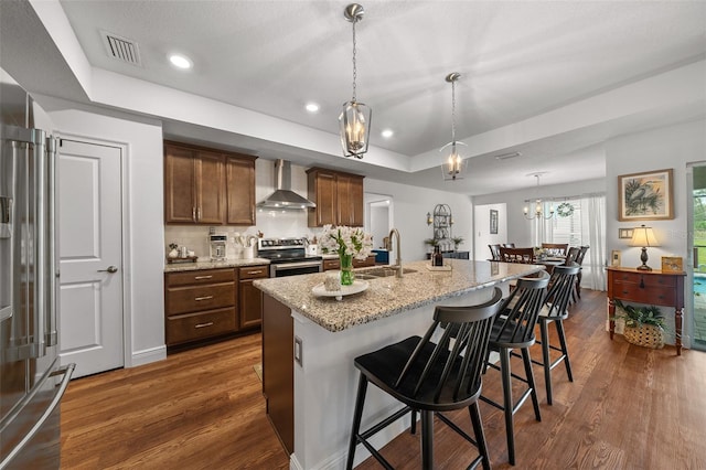 16386 Heron Hills Dr, Spring Hill, FL 34610 - kitchen featuring wall chimney exhaust hood, a tray ceiling, a sink, visible vents, and appliances with stainless steel finishes