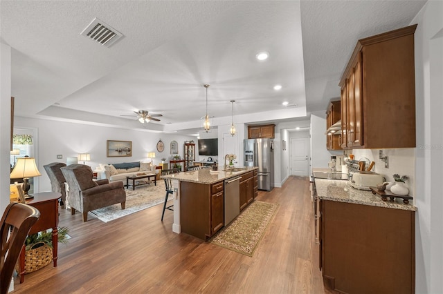 16386 Heron Hills Dr, Spring Hill, FL 34610 - kitchen with open floor plan, visible vents, a kitchen bar, a ceiling fan, and appliances with stainless steel finishes