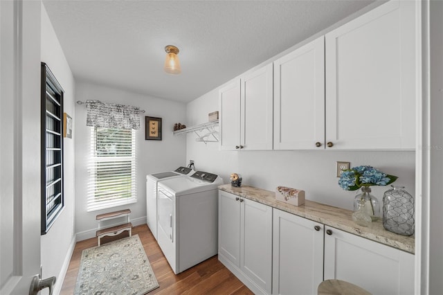 16386 Heron Hills Dr, Spring Hill, FL 34610 - laundry room featuring a textured ceiling, washer and clothes dryer, light wood-style floors, and cabinet space