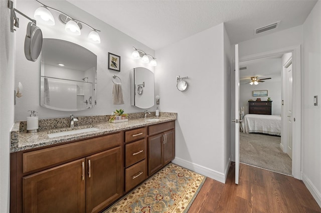 16386 Heron Hills Dr, Spring Hill, FL 34610 - ensuite bathroom with ceiling fan, wood finished floors, a sink, and visible vents