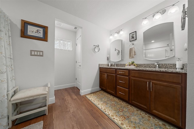 16386 Heron Hills Dr, Spring Hill, FL 34610 - full bathroom with baseboards, wood finished floors, a sink, and double vanity