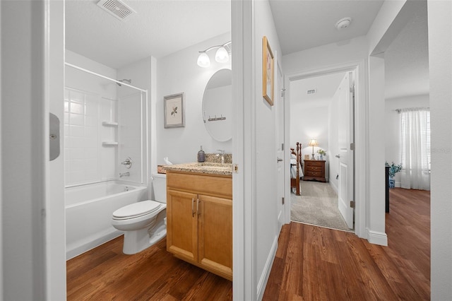 16386 Heron Hills Dr, Spring Hill, FL 34610 - ensuite bathroom with toilet, vanity, wood finished floors, and visible vents