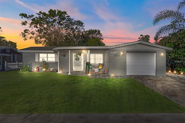 ranch-style house featuring driveway, a front yard, and a garage