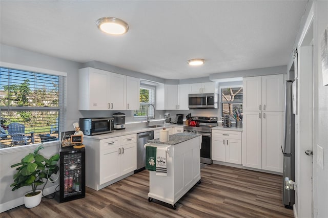 kitchen featuring a sink, dark wood-type flooring, white cabinetry, and stainless steel appliances