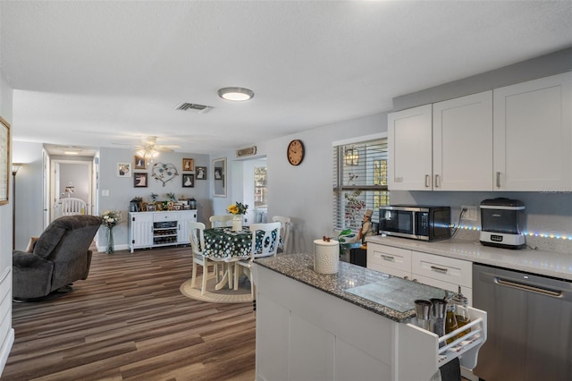 kitchen with visible vents, dark wood-style floors, white cabinetry, stainless steel appliances, and ceiling fan