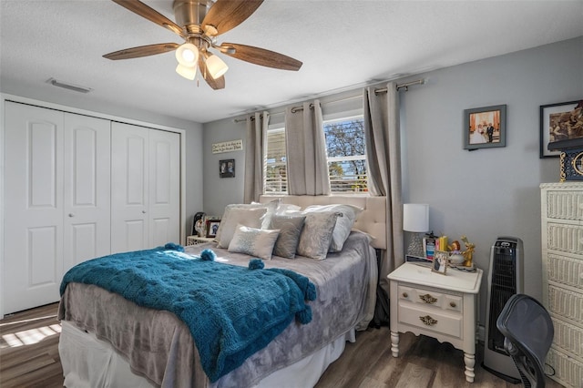 bedroom featuring wood finished floors, visible vents, ceiling fan, a closet, and a textured ceiling