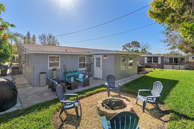 back of house featuring a patio, a lawn, an outdoor living space with a fire pit, and roof with shingles