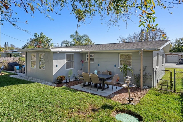 back of house with a yard, fence, and a gate