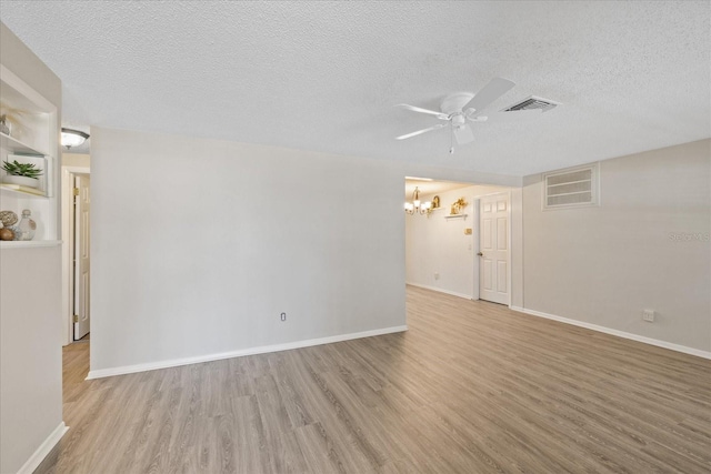 3728 Linkwood St, New Port Richey, FL 34652 - empty room with ceiling fan with notable chandelier, visible vents, a textured ceiling, and light wood-style floors