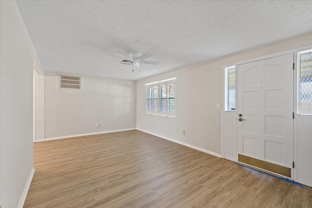 3728 Linkwood St, New Port Richey, FL 34652 - entrance foyer featuring light wood finished floors, a textured ceiling, baseboards, visible vents, and ceiling fan