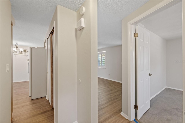 3728 Linkwood St, New Port Richey, FL 34652 - corridor featuring an inviting chandelier, wood finished floors, a textured ceiling, and baseboards