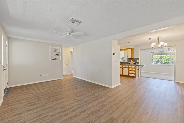 3728 Linkwood St, New Port Richey, FL 34652 - unfurnished living room featuring a textured ceiling, light wood finished floors, a chandelier, and ceiling fan