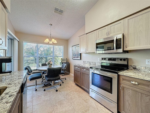 kitchen with visible vents, stainless steel appliances, light stone countertops, a chandelier, and vaulted ceiling