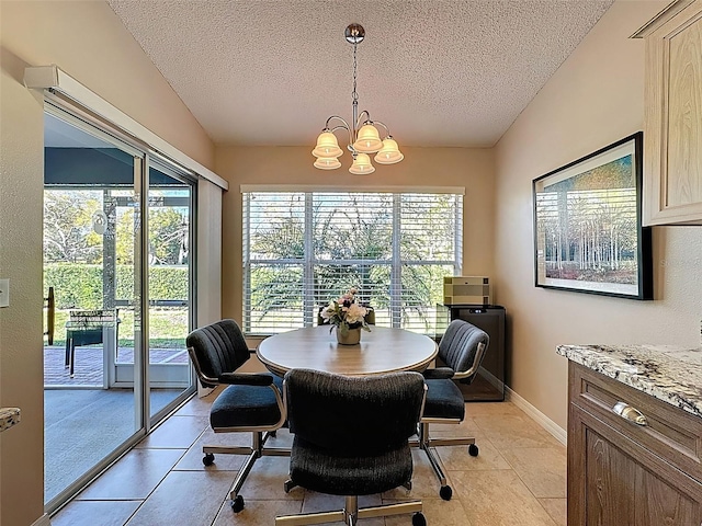 dining space with lofted ceiling, baseboards, a textured ceiling, and an inviting chandelier