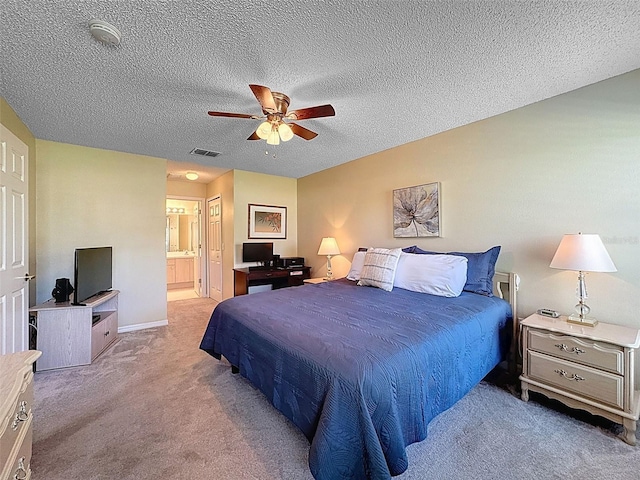 carpeted bedroom with visible vents, a textured ceiling, ensuite bath, baseboards, and ceiling fan