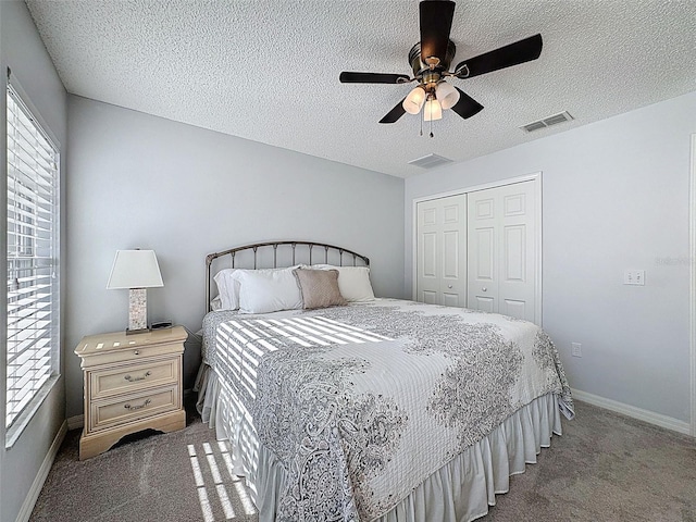 carpeted bedroom with multiple windows, baseboards, visible vents, and a closet