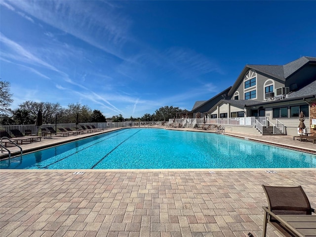 pool with a patio and fence