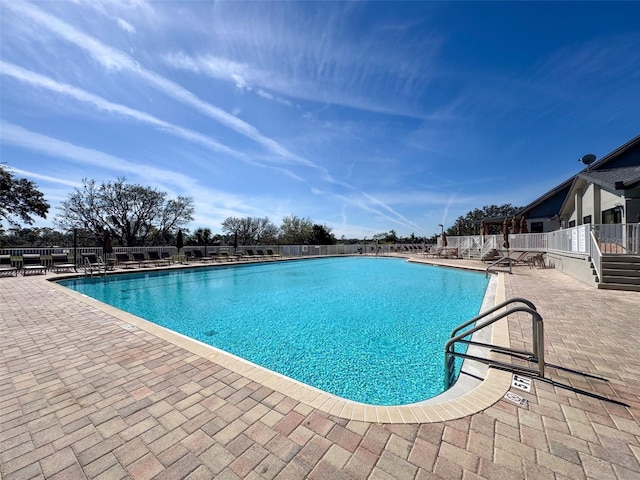 community pool featuring fence and a patio area