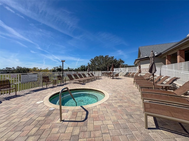 view of swimming pool with a patio area, a hot tub, and fence