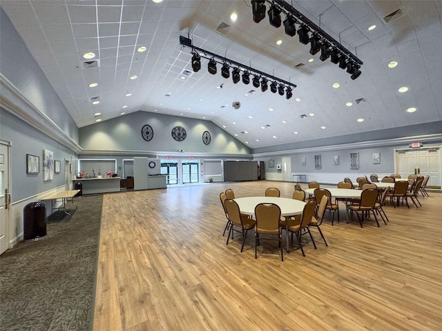 dining room featuring visible vents, high vaulted ceiling, track lighting, and wood finished floors