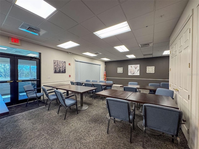 interior space with a drop ceiling, visible vents, and french doors