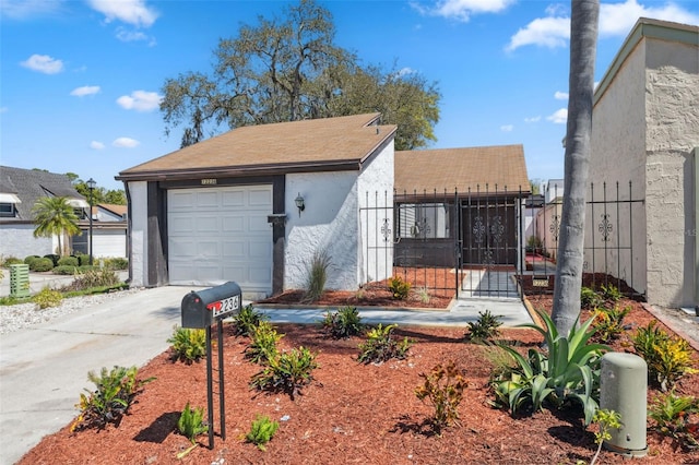 exterior space with stucco siding, driveway, a gate, fence, and an attached garage