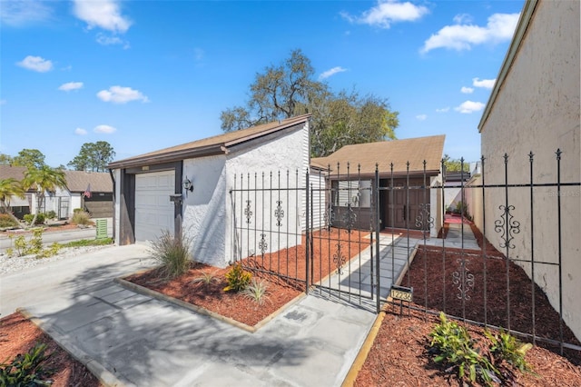 exterior space with a gate, an outdoor structure, driveway, and fence