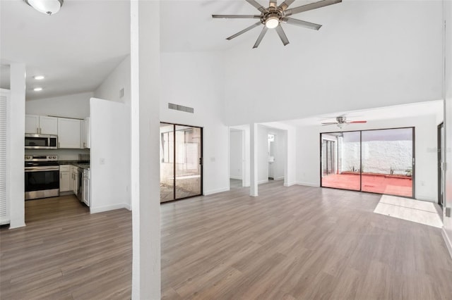 unfurnished living room featuring light wood finished floors, visible vents, baseboards, and ceiling fan