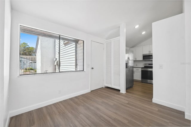 interior space with recessed lighting, baseboards, wood finished floors, and vaulted ceiling