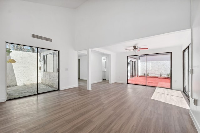 interior space featuring visible vents, wood finished floors, baseboards, and ceiling fan