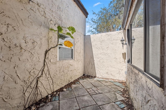 view of side of property with a patio and stucco siding