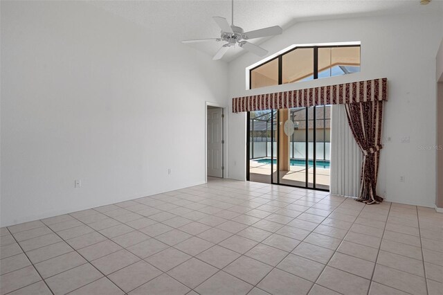 empty room with light tile patterned flooring, high vaulted ceiling, a textured ceiling, and ceiling fan