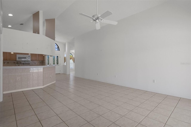 unfurnished living room featuring visible vents, recessed lighting, light tile patterned flooring, high vaulted ceiling, and a ceiling fan