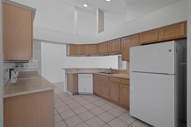 kitchen featuring a sink, white appliances, light tile patterned floors, and light countertops