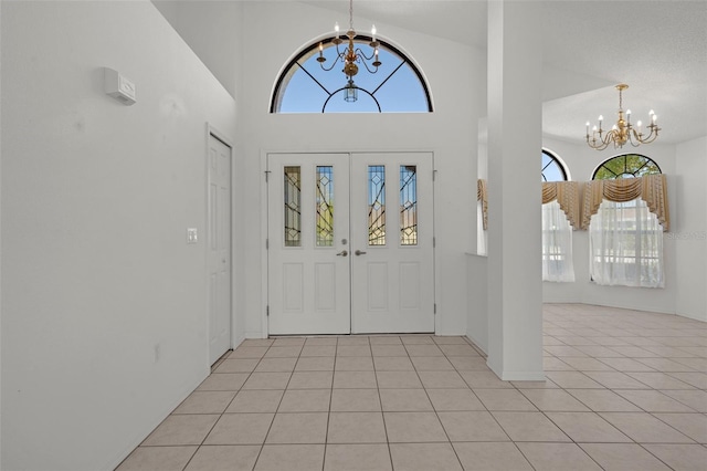 entryway with a notable chandelier, a high ceiling, and light tile patterned flooring