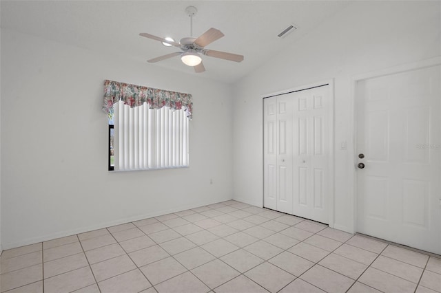 interior space with light tile patterned floors, visible vents, ceiling fan, and vaulted ceiling