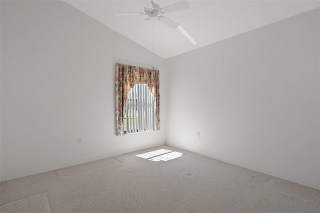 unfurnished room featuring a ceiling fan, vaulted ceiling, carpet, and baseboards