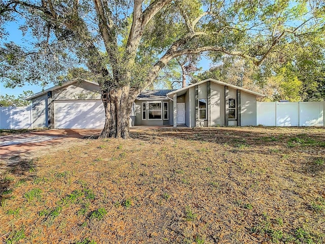 view of front of home featuring concrete driveway, fence, a garage, and stucco siding