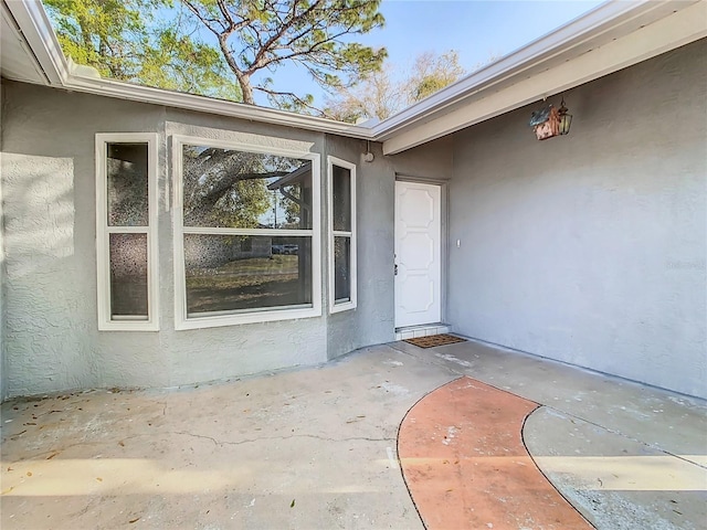 doorway to property with a patio area and stucco siding