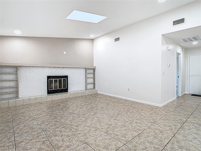 unfurnished living room with visible vents, baseboards, a skylight, and a fireplace