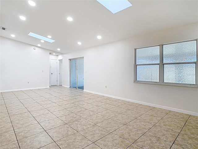 empty room featuring visible vents, recessed lighting, a skylight, and baseboards