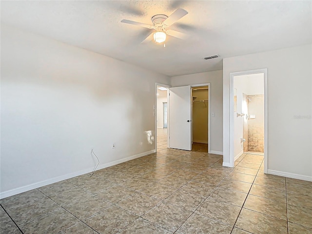 unfurnished bedroom with baseboards, visible vents, a spacious closet, a closet, and tile patterned floors